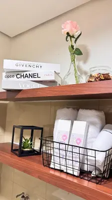 a shelf with towels and a vase with a flower at GreySky Studio in Manila