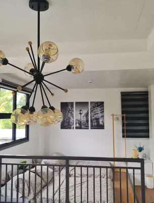 a dining room with a chandelier and a staircase at The Zentuary - House with pool in Amadeo