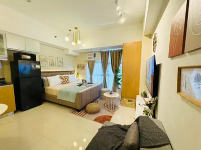 a bedroom with a bed and a tv in a room at Staycation in viceroy mckinley near venice grand canal in Manila