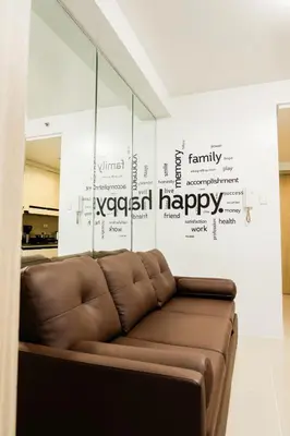 a brown couch in a room with a happy wall at Family Suite near MOA in Manila