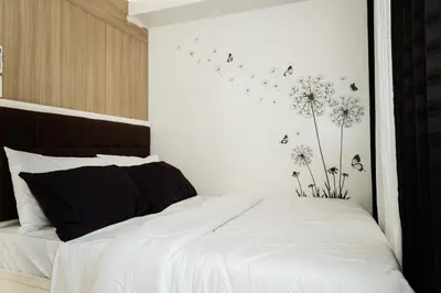 a bedroom with a bed with white sheets and dandelions at Family Suite near MOA in Manila