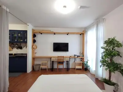 a living room with a table and a television on a wall at Delet TEA in Manila