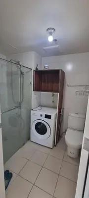 a small bathroom with a toilet and a washing machine at Rikki Staycation in Manila