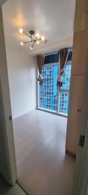 an empty room with a large window with a view of a building at Rikki Staycation in Manila