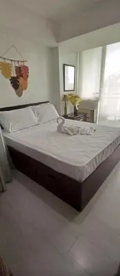 a bedroom with a large bed with white sheets at Casa Crisav Staycation place at AZURE in Manila