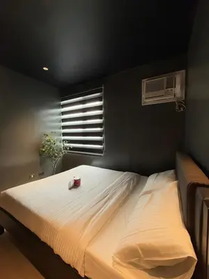 a bedroom with a large white bed with a window at Malate Bayview Mansion 37M in Manila
