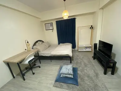 a room with a desk and a bed and a television at The Mood Shift in Manila