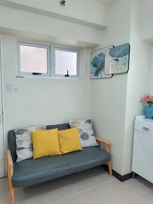 a blue couch in a room with two windows at Brixton place 2815 Weston tower in Manila