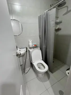 a bathroom with a toilet and a sink and a shower at Crisean Highrise Condo - 100 West makati in Manila