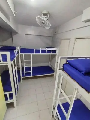 a room with three bunk beds with blue sheets at City Space in Manila