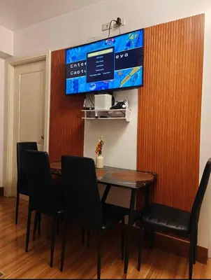a dining room with a table and chairs and a tv at Serenity Escapes by Aj in Manila