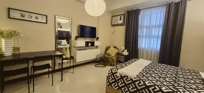 a bedroom with a bed and a desk and a television at A&G Condotel at 101newport Near NAIA T3 in Manila