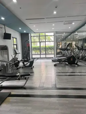 a gym with many treadmills and elliptical machines at J&M Cozy Retreat - McKinley Hill, BGC in Manila