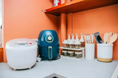 a kitchen counter with a blue mixer and utensils at Love, Lourdes Villa in Imus