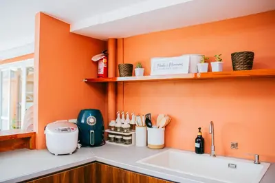 a kitchen with an orange wall and a sink at Love, Lourdes Villa in Imus