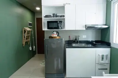 a kitchen with white cabinets and a refrigerator at The Beacon Condo T2-Studio in Manila