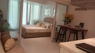 a bedroom with a bed and a desk and a mirror at Casa Crisav Staycation place at AZURE in Manila