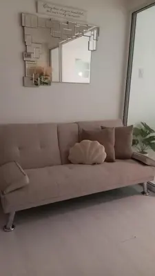 a brown couch in a living room with a mirror at Casa Crisav Staycation place at AZURE in Manila