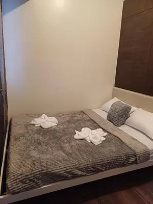 a bed with two towels on top of it at Urban Space 1BR with Balcony in Manila