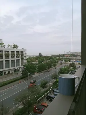 a cup of coffee on a balcony with a city street at Francheska Suite near Mall of Asia in Manila