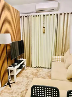 a living room with a couch and a table at AA Cozy Comfort in Nuvali in Calamba