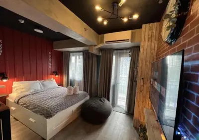 a bedroom with a bed in a room with red walls at LIXURY SUITES in S Residence Condo Pasay City in Manila