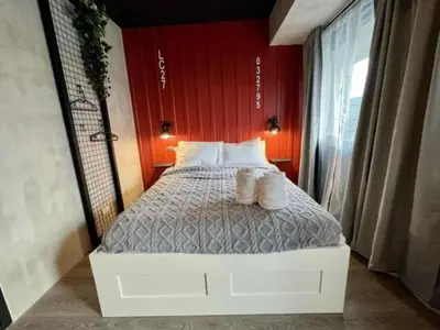 a bed in a room with a red wall at LIXURY SUITES in S Residence Condo Pasay City in Manila