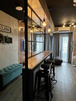 a room with a bar with stools and a couch at LIXURY SUITES in S Residence Condo Pasay City in Manila