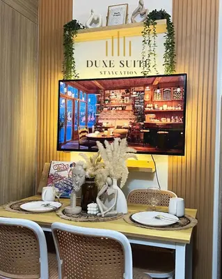 a table with chairs and a sign that reads dume surfsticks at Cozy Vibes near MOA & NAIA AIRPORT with NETFLIX,MINIVIDEOKE,BOARDGAMES-DUXE6 in Manila
