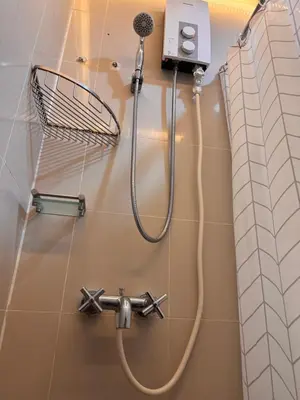 a shower in a bathroom with a shower head at Morgan Suites Executive Residences 2 in Manila