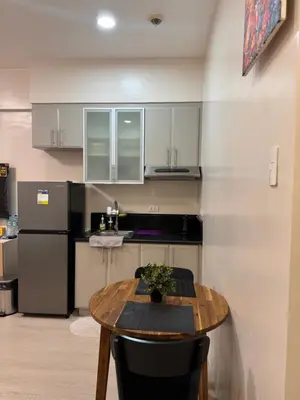 a kitchen with a table and a refrigerator at Morgan Suites Executive Residences 2 in Manila
