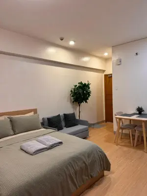 a bedroom with a bed and a table and a couch at Morgan Suites Executive Residences 3 in Manila