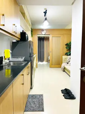 a kitchen with a sink and a refrigerator at Shell Residences Condotel by Aiza in Manila