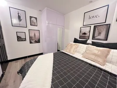a bedroom with a bed and pictures on the wall at Aesthetic 2BR Penthouse near NAIA with Pool in Manila