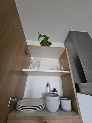 a kitchen with a sink and plates on shelves at Room with stunning view in Makati in Manila