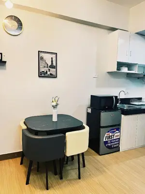 a dining room with a table and a kitchen at The Stars Lil' Suite in Trece Martires