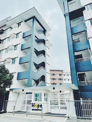 a apartment building with a hop sign in front of it at The Stars Lil' Suite in Trece Martires