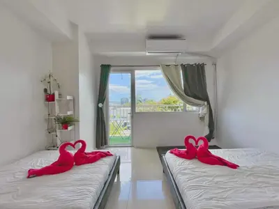 two pink swans sitting on two beds in a room at Shell Residences Mall of Asia FAMILY ROOM in Manila