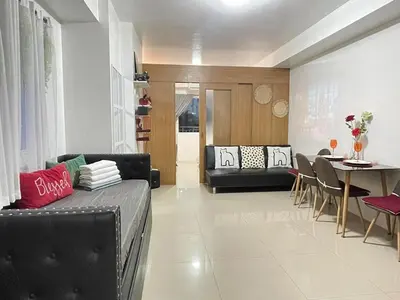 a living room with a couch and a table at Shell Residences Mall of Asia FAMILY ROOM in Manila