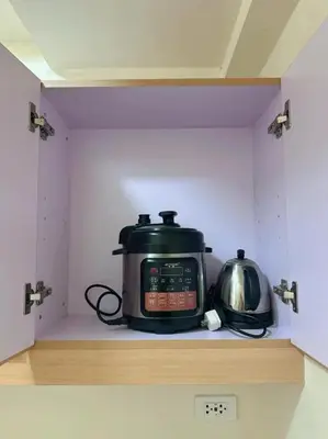 a slow cooker and a tea kettle sitting on a shelf at Brixton Place in Manila