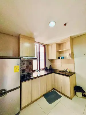 a kitchen with wooden cabinets and a refrigerator at Vincondotel Malate Manila 2BR Admiral 2823 in Manila