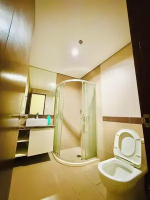 a bathroom with a shower and a toilet and a sink at Admiral Baysuites 2823 in Manila