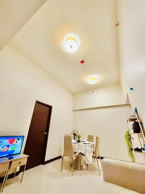 a dining room with a table and a television at Admiral Baysuites 2823 in Manila
