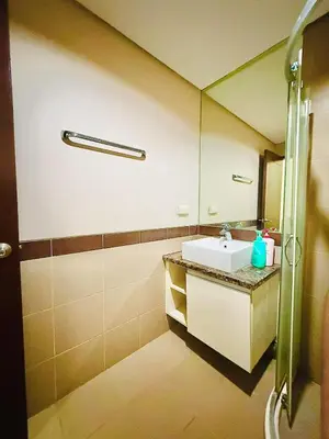 a bathroom with a sink and a mirror at Admiral Baysuites 2823 in Manila