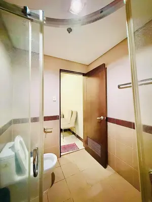 a bathroom with a shower and a toilet and a sink at Admiral Baysuites 2823 in Manila