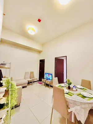 a living room with a table and chairs and a television at Admiral Baysuites 2823 in Manila