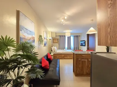 a living room with a couch and a kitchen at 1BR Condotel Ridgewood Towers Taguig City #RW16 in Manila