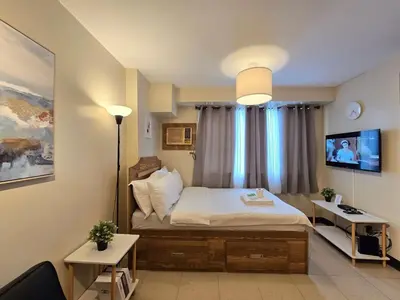 a bedroom with a bed and a television in it at 1BR Condotel Ridgewood Towers Taguig City #RW16 in Manila