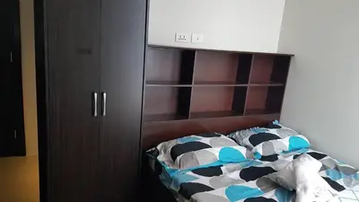 a bedroom with a bed and a brown cabinet at Araneta Cubao No Brown Outs 1BR Furnished Condo with Balcony free WiFi Netflix in Manila