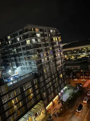 a tall building at night with a parking lot at Sea Residence in Manila